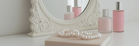 Elegant display of skincare products representing a vegan skincare routine for mature skin with a mirror and pearls.